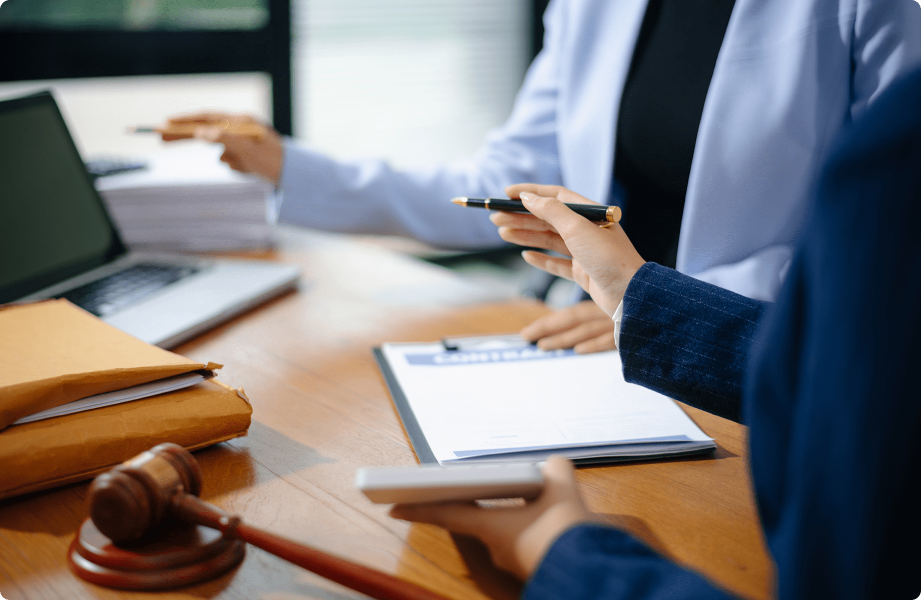Professionals reviewing legal paperwork in an office.