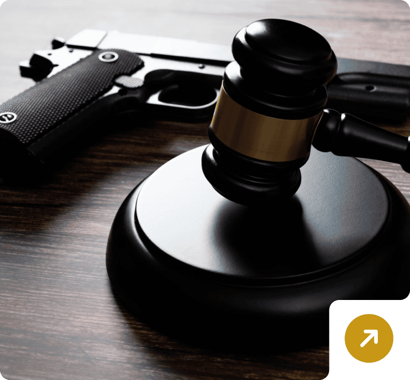 Gavel and handgun on wooden table