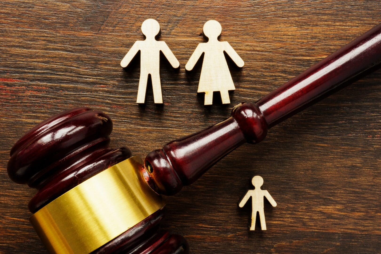 Gavel with family figures on wooden table